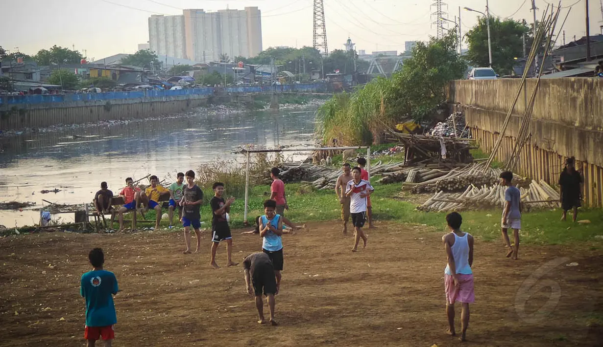 Meski lapangan dadakan tersebut tidak rata dan berdebu, anak-anak terlihat tetap antusias bermain di bantaran KBB, Jakarta, Kamis (11/9/14). (Liputan6.com/Faizal Fanani)  