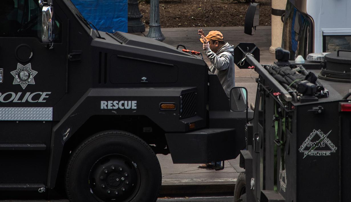 Seorang pelaku menyerahkan diri seusai melakukan aksi penembakan di dekat hotel sekaligus kasino terkemuka Cosmopolitan, Las Vegas, Sabtu (25/3). Polisi terlibat negosiasi sengit dengan pelaku selama berjam-jam. (L.E. Baskow/Las Vegas Sun via AP)