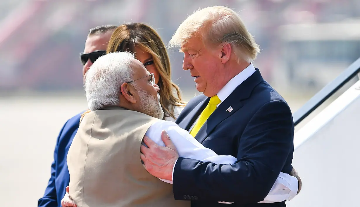 Perdana Menteri India, Narendra Modi (kiri) memeluk Presiden AS Donald Trump saat menyambut kedatangannya di Bandara Internasional Sardar Vallabhbhai Patel di Ahmedabad, Senin (24/2/2020). Trump tiba di India setelah melewati perjalanan panjang selama 17 jam dari Amerika Serikat. (MANDEL NGAN/AFP)