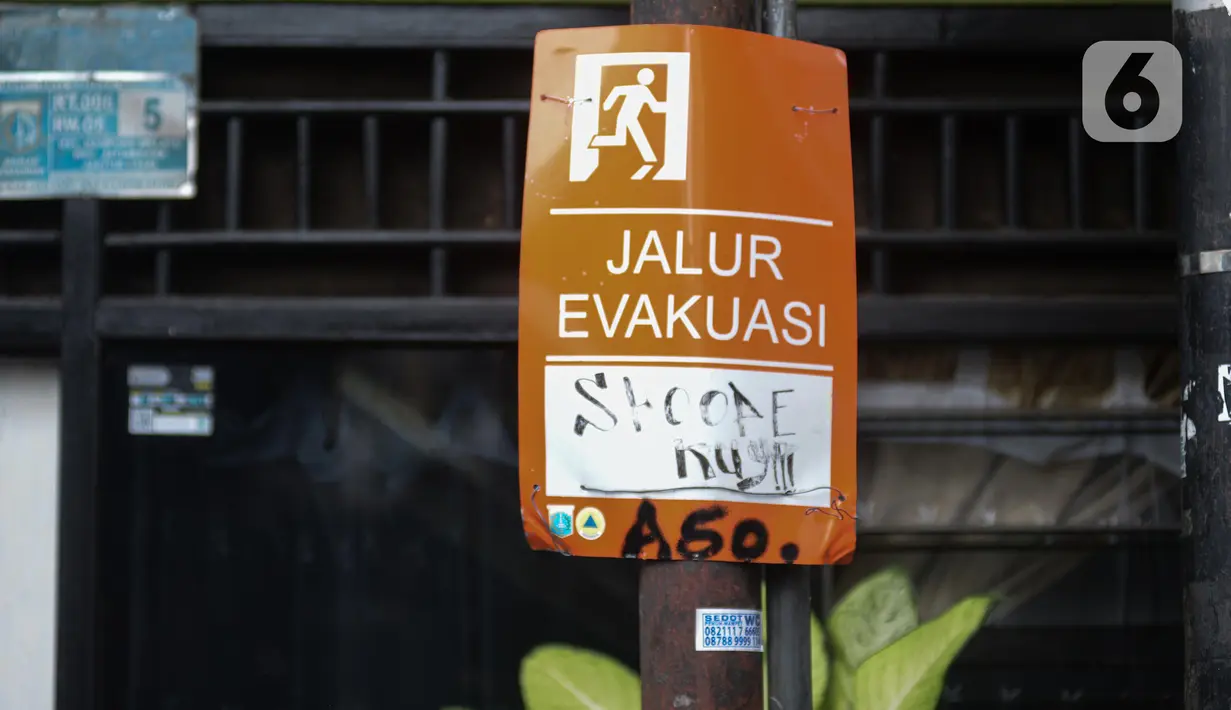 Tanda jalur evakuasi terlihat di tengah banjir yang merendam kawasan Kebon Pala, Kampung Melayu, Jakarta Timur, Sabtu (16/7/2022). Banjir itu disebut akibat luapan Kali Ciliwung akibat hujan deras yang mengguyur wilayah Jakarta, Bogor, dan Depok sejak Jumat (15/7/2022) malam hingga Sabtu pagi. (merdeka.com/Imam Buhori)