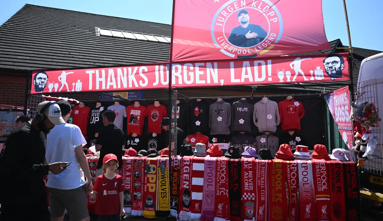 Merchandise yang menampilkan manajer Liverpool asal Jerman, Jurgen Klopp, terlihat dijual di luar lapangan saat para penggemar tiba untuk menyaksikan laga pekan ke-38 Premier League melawan Wolverhampton Wanderers di Stadion Anfield, Minggu (19/5/2024). (Paul ELLIS / AFP)