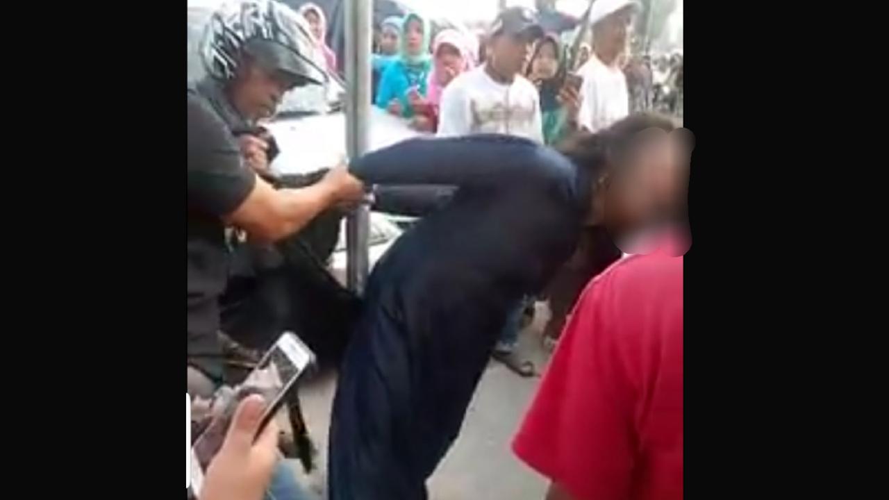 Emak-emak diikat di tiang listrik karena mencuri telepon genggam (Fauzan/Liputan6.com)