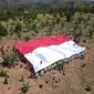 Pembentangan Bendera Merah Putih raksasa oleh puluhan eks napiter di Kabupaten Poso, Jumat (16/8/2024). (Foto: Satgas Madago Raya).