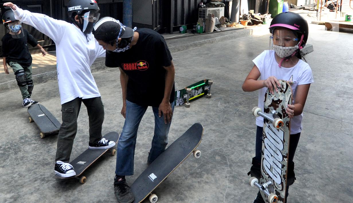 Sejumlah anak dengan menggunakan masker dan face shield berlatih skateboard di Crooz Shophouse di kawasan Duren Tiga, Jakarta Selatan, Minggu (2/8/2020). Sekitar tiga minggu ini mereka kembali melakukan latihan seminggu dua kali dengan menerapkan protokol kesehatan. (merdeka.com/Arie Basuki)