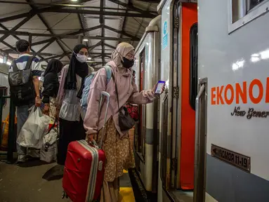 Para penumpang menaiki kereta api di stasiun kereta api Lempuyangan, Yogyakarta pada 14 Maret 2026. Sepekan jelang Hari Raya Idul Fitri 1447 Hijriah, kepadatan arus mudik mulai terasa di Stasiun Lempuyangan, Kota Yogyakarta. (DEVI RAHMAN/AFP)