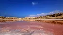 Sebuah gambar yang diambil pada 26 Januari 2021 ini memperlihatkan air di danau merah muda yang terletak di Ras Al Khaimah di Uni Emirat Arab (UEA). Danau merah muda adalah efek dari ganggang merah menyebabkan perubahan warna air. (GIUSEPPE CACACE/AFP)