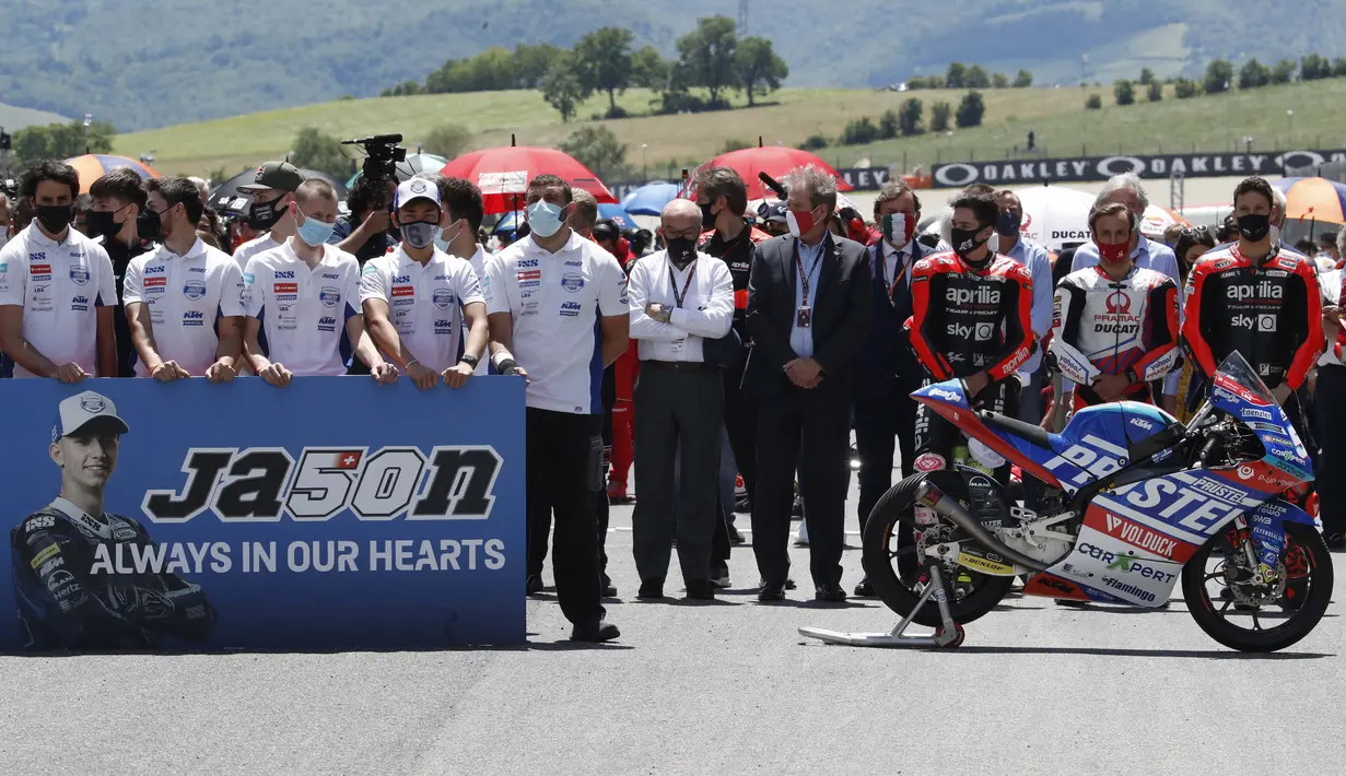 Anggota tim CarXpert PrustelGP beserta sejumlah pebalap MotoGP melakukan penghormatan terakhir bagi Jason Dupasquier sebelum dimulainya balapan MotoGP Italia di Sirkuit Mugello. (Foto: AP Photo/Antonio Calanni)