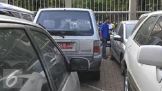 Peserta lelang mengecek mobil dinas KPK yang akan dilelang di halaman KPK, Selasa (1/9/2015). KPK akan melelang 21 mobil dan 8 motor operasional yang sudah tidak digunakan lagi pada Rabu (2/9) melalui KPKNL Jakarta III. (Liputan6.com/Herman Zakharia)