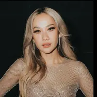 Rambut silvernya dibiarkan terurai dengan gaya belah duanya tanpa poni yang mengekspos keningnya. [@itsmebcl]