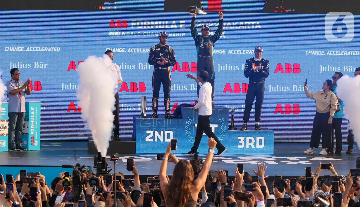 Pembalap Jaguar TCS Mitch Evans (tengah) berselebrasi setelah Presiden Joko Widodo (kedua kanan) memberikan trofi usai menjuarai balapan Formula E seri kesembilan di Jakarta International E-Prix Circuit (JIEC), Jakarta, Sabtu (4/6/2022). Andalan Jaguar TCS Racing Mitch Evans memenangkan ajang balap Formula E Jakarta e-Prix 2022. (Liputan6.com/Herman Zakharia)