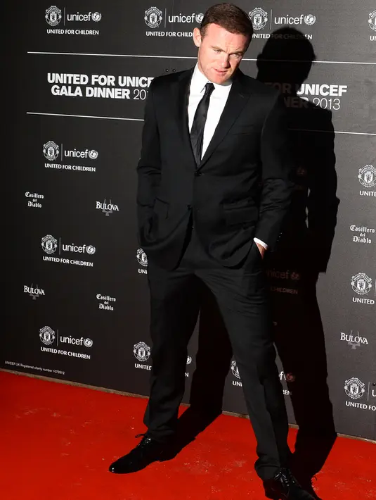 Penyerang Inggris, Wayne Rooney bertingkah aneh saat berpose sebelum makan malam dengan UNICEF di Old Trafford di Manchester pada 21 November 2013. (AFP PHOTO / PAUL ELLIS )