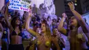 Dua orang wanita bertelanjang dada saat menggelar protes pelarangan aborsi di Rio de Janeiro, Brasil (13/11). Ribuan orang turun ke jalan untuk menggelar protes adanya larangan aborsi di Brasil. (AFP Photo/Mauro Pimentel)