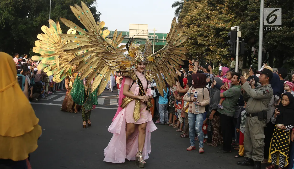 Peserta mengenakan busana nusantara saat memeriahkan Jakarnaval 2018 di Jalan Medan Merdeka Selatan, Jakarta, Minggu (8/7). Karnaval dimeriahkan oleh beragam atraksi dan pawai budaya Nusantara. (Liputan6.com/Herman Zakharia)