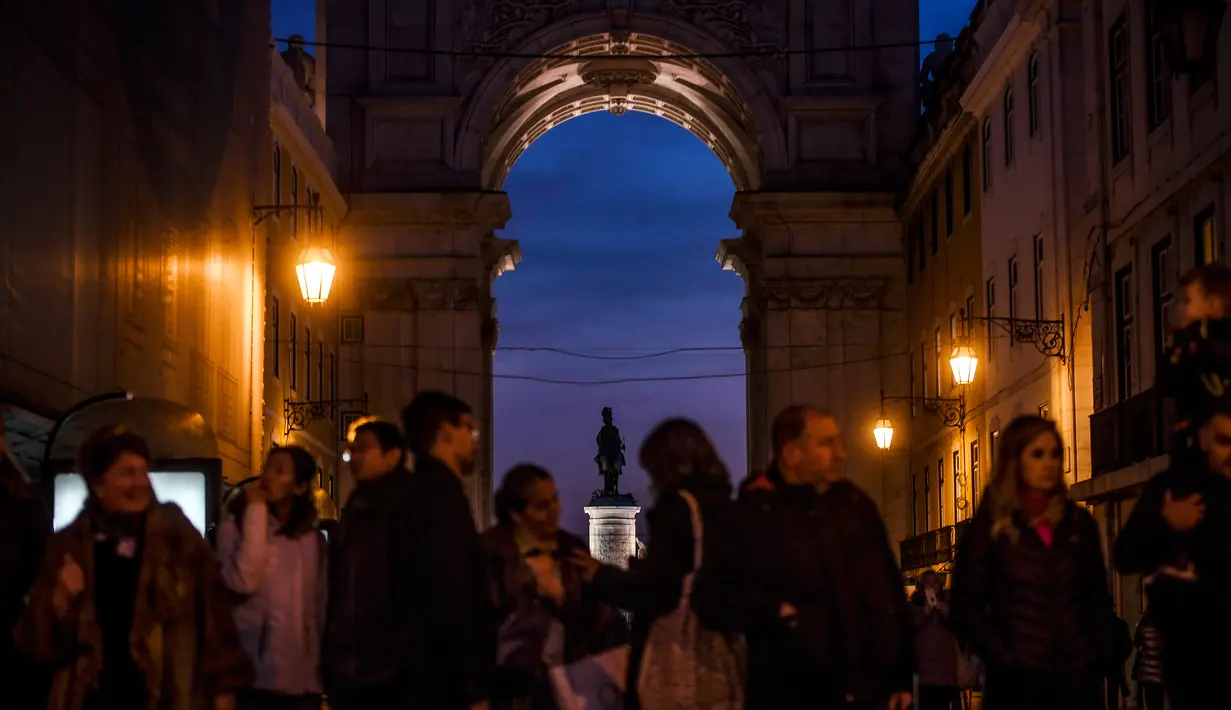 Orang-orang menunggu menyeberang jalan di Rua Augusta Arch di Lisbon (17/12). Penduduk kota ini berjumlah 600.000 jiwa dan di daerah metropolitan sekitar 2,5 juta jiwa. Jumlah ini kira-kira 1/3 penduduk Portugal. (AFP Photo/Patricia De Melo Moreira)