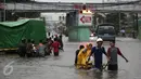 Warga menaiki gerobak untuk menyeberangi banjir yang merendam Jalan Gunung Sahari, Jakarta Pusat, Selasa (21/2). Hujan yang turun sejak dini hari menyebabkan sejumlah ruas jalan terimbas banjir dan tak bisa dilalui kendaraan. (Liputan6.com/Faizal Fanani)