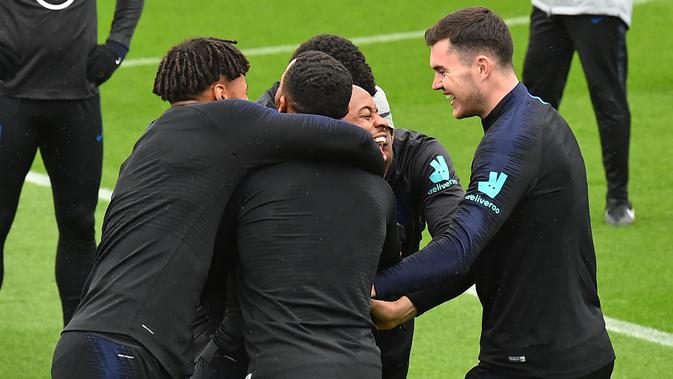 Gelandang Inggris, Raheem Sterling (tengah) tertawa saat ditangkap dalam pertandingan Kabaddi selama sesi pelatihan tim  di Staplewood Campus di southampton, Inggris  (9/9/2019). Inggris akan bertanding melawan Kosovo pada grup A Kualifikasi Euro 2020 di Stadion Saint Mary. (AFP Photo/Glyn Kirk)