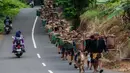 Mereka berjalan kaki dengan membawa berbagai macam hasil bumi di antaranya hewan ternak, beras, dan makanan ringan untuk dimasak dan dibagikan sebagai cara untuk menyambut datangnya bulan suci Ramadan. (DEVI RAHMAN/AFP)