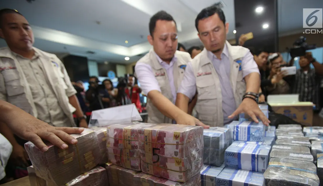 Petugas menata barang bukti hasil tindak pidana pencucian uang (TPPU) kasus narkoba di kantor BNN, Jakarta, Selasa (13/6). Total senilai Rp 39 miliar disita dari empat tersangka yang terkait dengan jaringan Freddy Budiman. (Liputan6.com/Yoppy Renato)