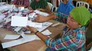 Seorang petugas sortir memperlihatkan lembaran surat suara yang rusak saat melakukan pernyortiran surat suara di GOR Palabuhanratu, Sukabumi, Jabar. (Antara)