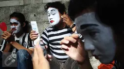 Sejumlah pria merias wajahnya jelang memperingati World Mime Day 2017 di CFD, Jakarta, Minggu (19/3). Tanggal 22 Maret adalah hari kelahiran Maestro Mime "Marcel Marceau". (Liputan6.com/Angga Yuniar)