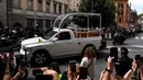 Umat bisa menyaksikan langsung iring-iringan mobil jenazah Paus Fransiskus yang melintas dari balik pembatas besi sepanjang rute. (HENRY NICHOLLS/AFP)