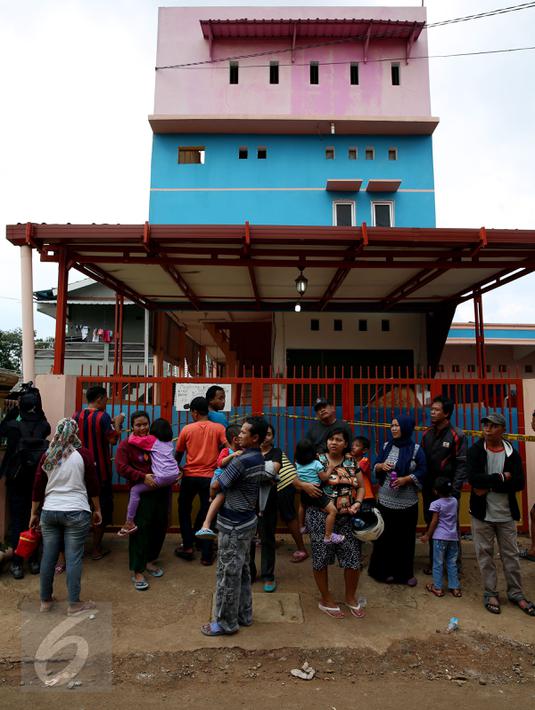 Sejumlah warga melihat rumah kos-kosan terduga anggota jaringan teroris, Bekasi (11/12). Polisi juga menemukan bom seberat 3 kilogram di tempat tersebut. (Liputan6.com/JohanTallo)