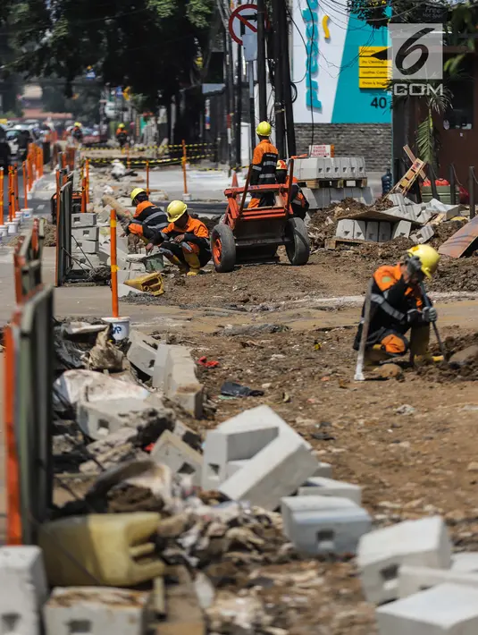 Pekerja menyelesaikan proyek revitaslisasi trotoar di kawasan Cikini, Jakarta, Senin (1/7/2019). Revitalisasi trotoar di kawasan Cikini hingga Kramat ditargetkan rampung pada Desember 2019. (Liputan6.com/Faizal Fanani)