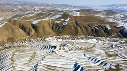 Foto dari udara yang diabadikan pada 7 Desember 2020 ini menunjukkan pemandangan sawah terasering yang tertutup salju di Kota Wuwei, Wilayah Otonom Etnis Tibet Tianzhu, Provinsi Gansu, China barat laut. (Xinhua/Jiang Aiping)