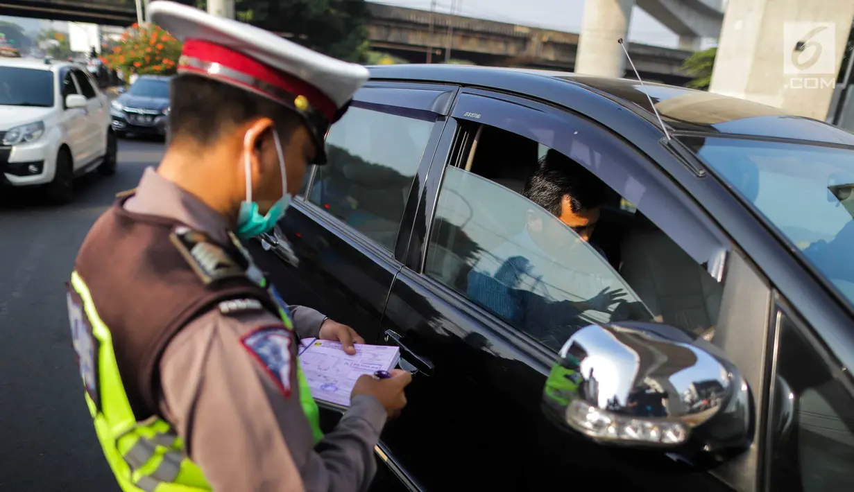 Polisi menilang kendaraan saat pemberlakuan perluasan sistem ganjil genap di kawasan Jalan Fatmawati Raya, Jakarta, Senin (9/9/2019). Pada masa uji coba, polisi hanya melakukan upaya preventif seperti sosialisasi kepada pelanggar. (Liputan6.com/Faizal Fanani)