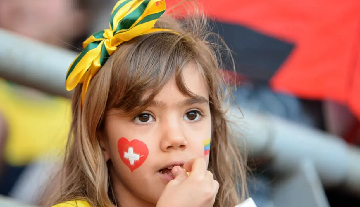 Sambil menikmati makanan kecil, pendukung muda "Scweizer Nati" setia menunggu dimulainya laga Swiss kontra Ekuador di Estadio Nacional de Brasilia, (15/6/2014). (AFP PHOTO/Adrian Dennis)