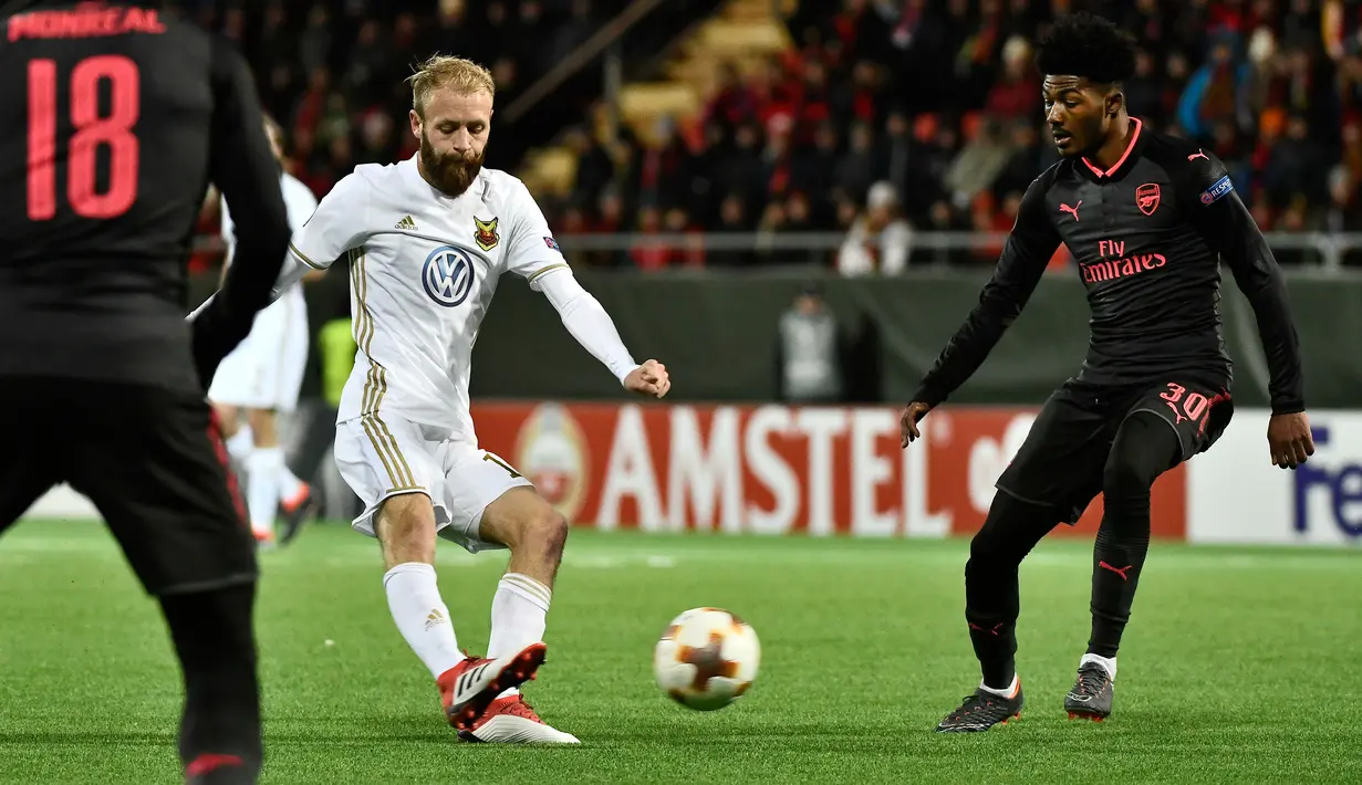 Pemain Arsenal, Ainsley Maitland-Niles berebut bola dengan pemain Ostersunds, Curtis Edwards pada laga leg pertama babak 32 besar Liga Europa di Jamtkraft Arena, Jumat (16/2). Arsenal meraih kemenangan mudah 3-0. (Robert Henriksson/TT News Agency via AP)