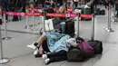Seorang penumpang maskapai Viva Air tidur di bandara setelah maskapai berbiaya rendah itu menangguhkan operasinya di Bandara Internasional El Dorado di Bogota, Kolombia, Selasa (28/2/2023). Sejumlah penumpang bermalam di bandara, banyak yang tidur di lantai sambil menunggu penerbangan ke tujuan yang dituju. (AP Photo/Fernando Vergara)