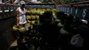 Pekerja menurunkan gas tiga kg dari mobil di agen elpiji di Karet Kuningan, Jakarta, Selasa (26/5/2015). Untuk menghindari subsidi yang tidak tepat sasaran, Pertamina melabeli gas tiga Kg dengan "Hanya untuk Masyarakat Miskin". (Liputan6.com/Johan Tallo)