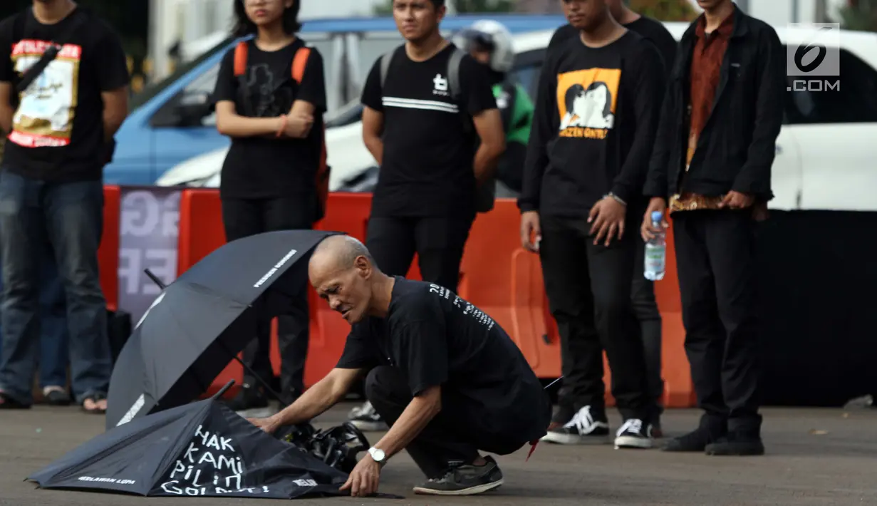 Peserta aksi Kamisan saat aksi di kawasan Silang Monas depan Istana Negara, Jakarta, Kamis (7/2). Seiring aksi Kamisan, JSKK meminta komitmen pemerintah untuk menyelesaikan kasus pelanggaran HAM masa lalu. (Liputan6.com/Helmi Fithriansyah)