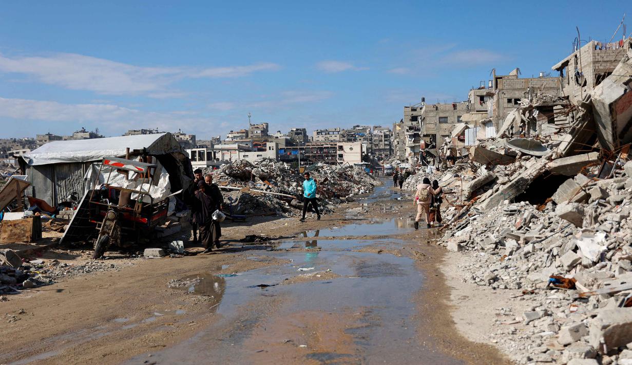 Komite ini akan diawasi oleh mantan koordinator perdamaian Timur Tengah Perserikatan Bangsa-Bangsa (PBB) asal Bulgaria, Nickolay Mladenov. Tampak dalam foto, para pengungsi Palestina hidup di tengah reruntuhan rumah dan bangunan yang hancur akibat serangan militer Israel selama lebih dari dua tahun di wilayah Gaza, di kamp pengungsi Jabalia, di bagian utara Jalur Gaza pada Sabtu 17 Januari 2026. (Omar AL-QATTAA/AFP)