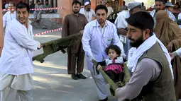 Petugas membawa anak yang menjadi korban gempa di Jalalabad, Afghanistan, Senin (26/10/2015). Sekitar 43 orang dipastikan tewas akibat lindu berkekuatan 7,5 skala Richter tersebut. (REUTERS/Parwiz)