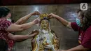 Para jemaat menyikat patung yang ada di Vihara Amurva Bhumi, Jakarta, Kamis (4/2/2021). Ritual mencuci patung dewa serta bersih-bersih ini dilakukan dalam rangka menyambut perayaan Tahun Baru Imlek 2572. (Liputan6.com/Faizal Fanani)