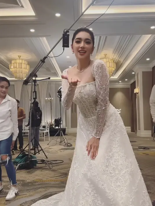 Melengkapi tampilannya dengan perhiasan silver dari kalung tanpa liontin hingga anting-anting model mutiara. Wajahnya dipoles blush on coral dan lipstik matte maroon. [@realangelkaramoy]