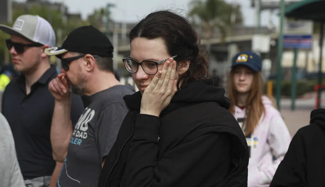 Seorang pengungsi Ukraina menunggu transportasi setelah melintasi perbatasan AS-Meksiko di San Ysidro, California, pada 4 April 2022. Ratusan warga Ukraina menunggu di sebuah perkemahan di Tijuana, selatan San Diego, berharap untuk mencari suaka AS. (SANDY HUFFAKER/AFP)
