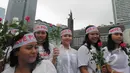 Dalam aksi damai "Save Polri" peserta aksi membagikan bunga mawar kepada warga, Bundaran HI, Jakarta, Minggu (1/2/2015). (Liputan6.com/Herman Zakharia)