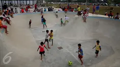 Sejumlah anak bermain di area skate board di Kalijodo, Jakarta, Rabu (4/1). Mengisi hari libur Kalijodo dipenuhi ratusan warga, Anak - anak, orang tua, remaja bermain memeras tenaga untuk memuaskan adrenalin mereka. (Liputan6.com/Johan Tallo)