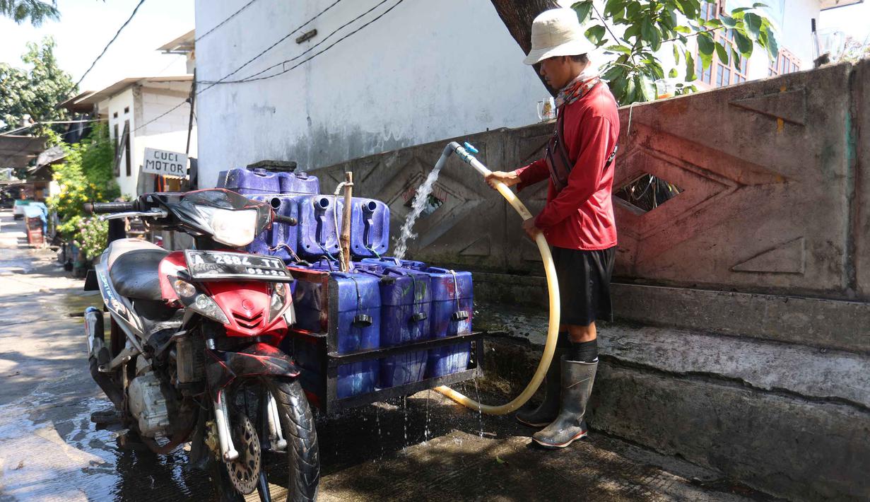 Pedagang mengisi jeriken dengan air bersih untuk segera didistribusikan kepada pelanggan di Kawasan Muara Angke, Jakarta, Kamis (28/5/2026). (Kapanlagi.com/Budy Santoso)