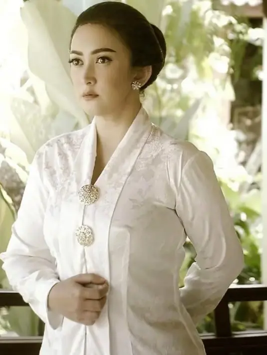 Dengan sanggul klasik, Nafa mengenakan kebaya putih dan bros dua keemasan serasi dengan anting-antingnya. [@nafaurbach]