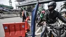 Pengendara melintasi penyekatan mobilitas di Jalan Basuki Rahmat, Jakarta Timur, Kamis (15/7/2021). Kendaraan yang diperbolehkan melintas hanya yang bekerja di sektor esensial dan kritikal serta pengendara yang memiliki Surat Tanda Registrasi Pekerja (STRP). (merdeka.com/Iqbal S Nugroho)