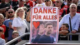 Pendukung Bayer Leverkusen memegang poster pelatih, Xabi Alonso dalam acara perpisahan setelah laga lanjutan Liga Jerman 2024/2025 melawan Borussia Dortmund di BayArena, Leverkusen, Jerman, Minggu (11/05/2025) waktu setempat. (AFP/Ina Fassbender)