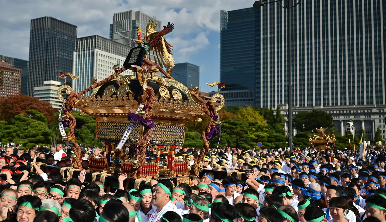 Peserta berkumpul selama perayaan nasional untuk menandai penobatan Kaisar Jepang Naruhito di depan Istana Kekaisaran di Tokyo (9/11/2019). Kaisar Naruhito menggantikan posisi ayahnya, Akihito yang menjadi kaisar pertama yang turun tahta. (AFP Photo/Charly Triballeau)