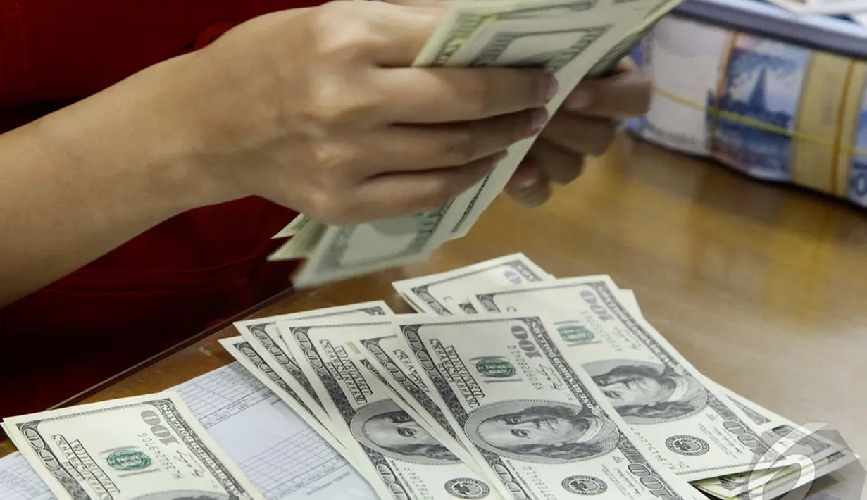 Pegawai Bank sedang menghitung dengan seksama mata uang dollar yang akan ditukarkan dengan rupiah, Jakarta, Kamis (23/10/2014) (Liputan6.com/Johan Tallo) 