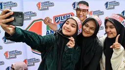 Pendukung Calon Presiden nomor urut 1, Anies Baswedan berswafoto saat mengikuti kampanye pemilu di Banda Aceh pada 27 Januari 2024. (CHAIDEER MAHYUDDIN/AFP)