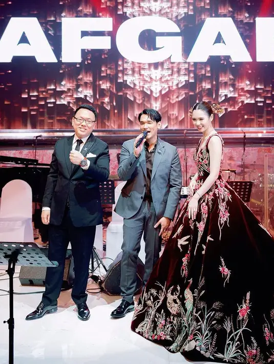 Di acara pertunangan, Gwen tampil mengenakan ball gown maroon yang terinspirasi style Maroko. Memiliki detail bordiran bunga dan beberapa hewan. Ryan mengenakan setelan jas hitamnya. [@nancywarrencouture]