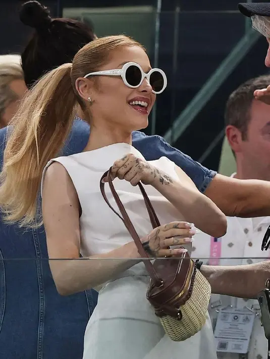 Setelah menghadiri Upacara Pembukaan dengan gaun sutra berpinggang rendah warna merah muda Glinda karya Thom Browne, penyanyi itu tampil bergaya retro di babak kualifikasi senam artistik putri pada hari Minggu. Ia melengkapi gayanya dengan sepasang kacamata hitam bundar besar berbingkai putih dan tas tangan anyaman yang menampilkan detail kulit cokelat.  [@galindamoonlightt].